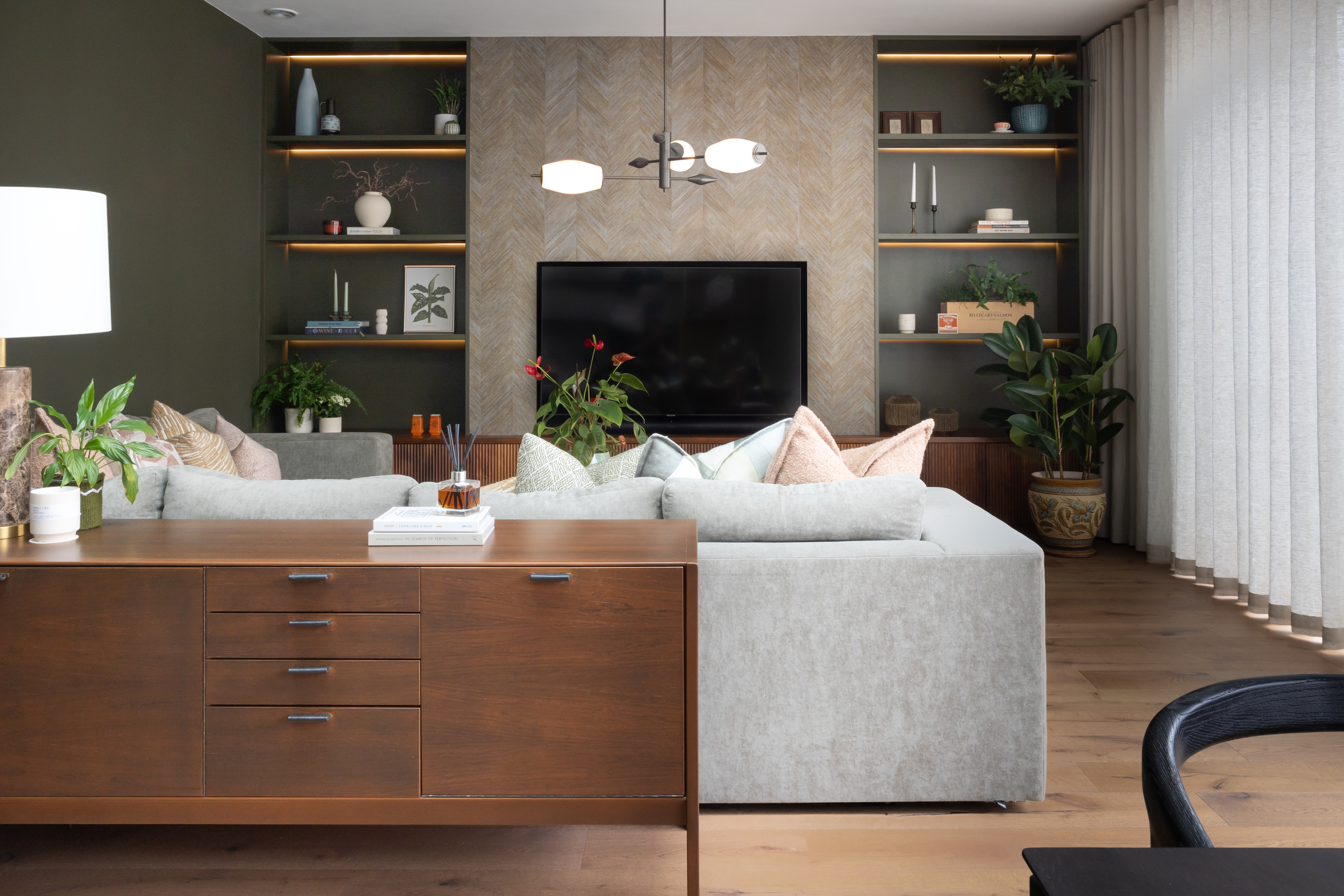 A contemporary living room with sideboard and open shelving arranged artfully with plenty of free space