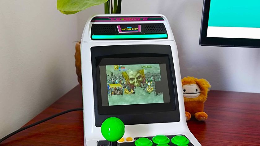 Sega Astro City Mini arcade machine on woodgrain desk with Golden Axe: The Revenge of Death Adder on screen.