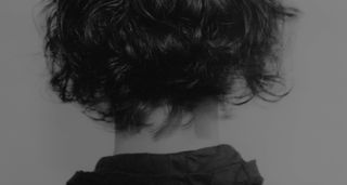 A black and white portrait of the back of a head