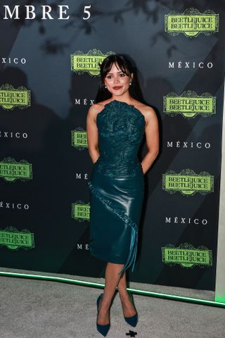 Jenna Ortega poses during the 'Beetlejuice Beetlejuice' fan event at Plaza Toreo Parque Central on August 14, 2024 in Naucalpan de Juarez, Mexico wearing a green leather dress