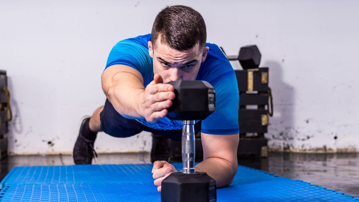 a photo of a man doing a plank reach