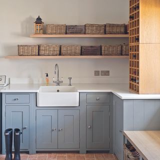 Light blue shaker kitchen with open shelving with baskets on top.