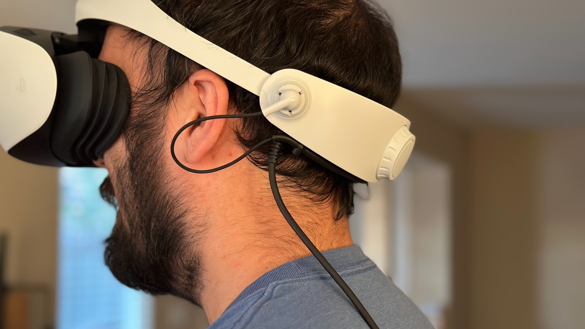 Back of the Sony PS VR2 headset on the author's head, showing the main cable laying on his left shoulder and back.