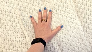 Reviewer's hand on the quilted top of the Sleep Number c1 smart bed