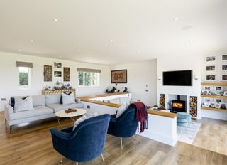 white open plan living room with half wall partition, stove and sunken area