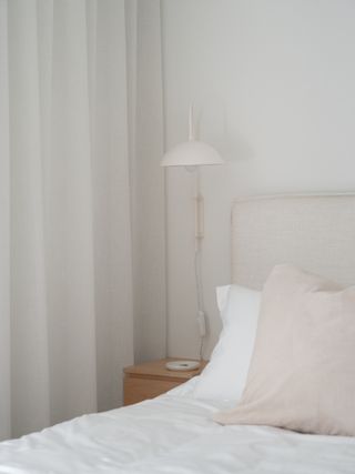 A small bedroom with a slim nightstand by the bed