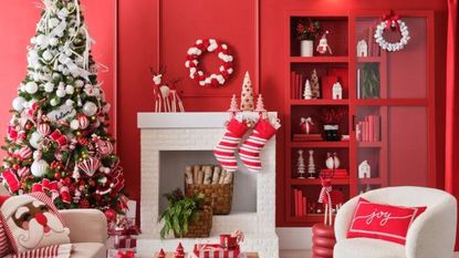 A room with red walls and a white fireplace, decorated with pieces from the Michaels Holiday Collection.