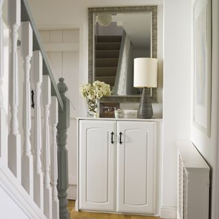 hallway with white cabinet and stairs