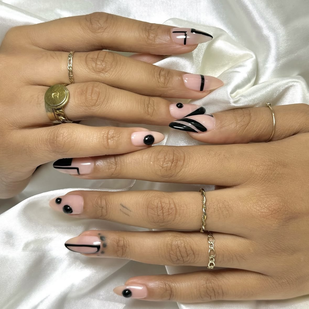 A nude manicure with modern black detailing.
