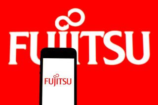The Fujitsu logo on a smartphone and the wall in the background