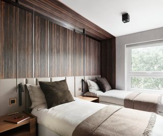 dark wooden wall panelling on walls and ceiling around bed creating the feeling of an alcove