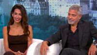 Amal and George Clooney sitting in white chairs being interviewed on CBS Mornings 