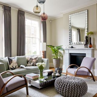 sitting room with pouffe seat and relaxing chairs with glass table and flower jar