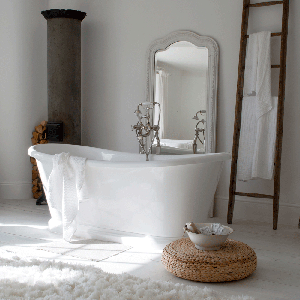 bathroom with white bathtub mirror and floor mat