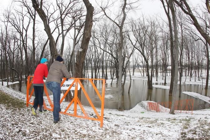 Workers survey the flooding at the 'cross worlds course