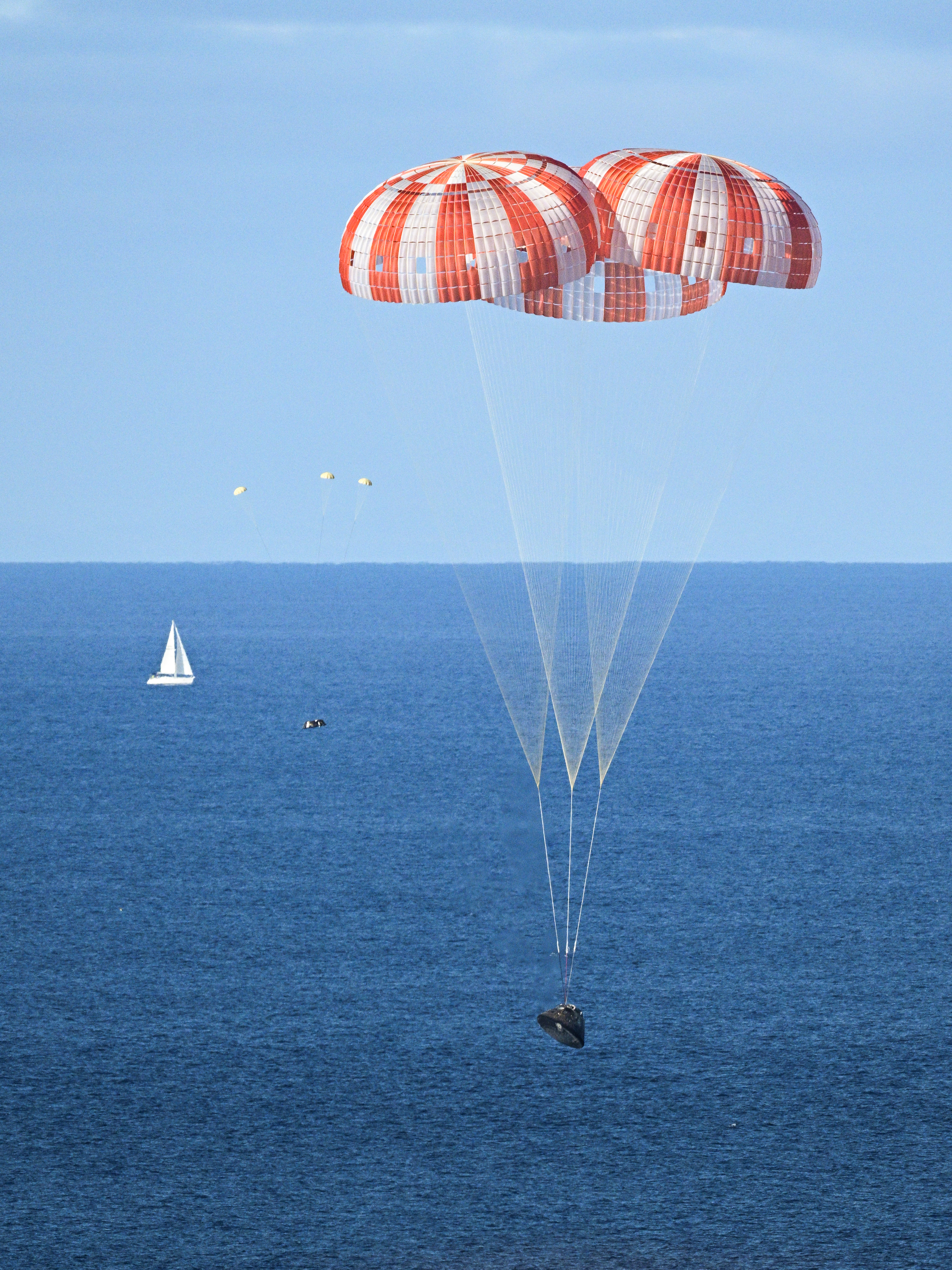 PHOTO DATE: April 10, 2026.LOCATION: Off the coast of California. SUBJECT: NASA&rsquo;s Orion capsule descends under its main parachutes over the Pacific Ocean following a successful 1-day Artemis II mission, April 10, 2026. PHOTOGRAPHER: Josh Valcarcel