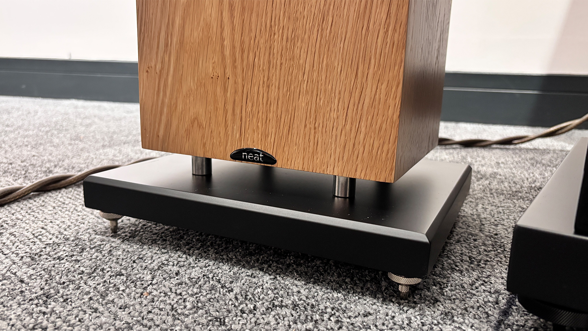 Neat Mystique Classic floorstanding speakers on grey carpet, detail of base of speaker