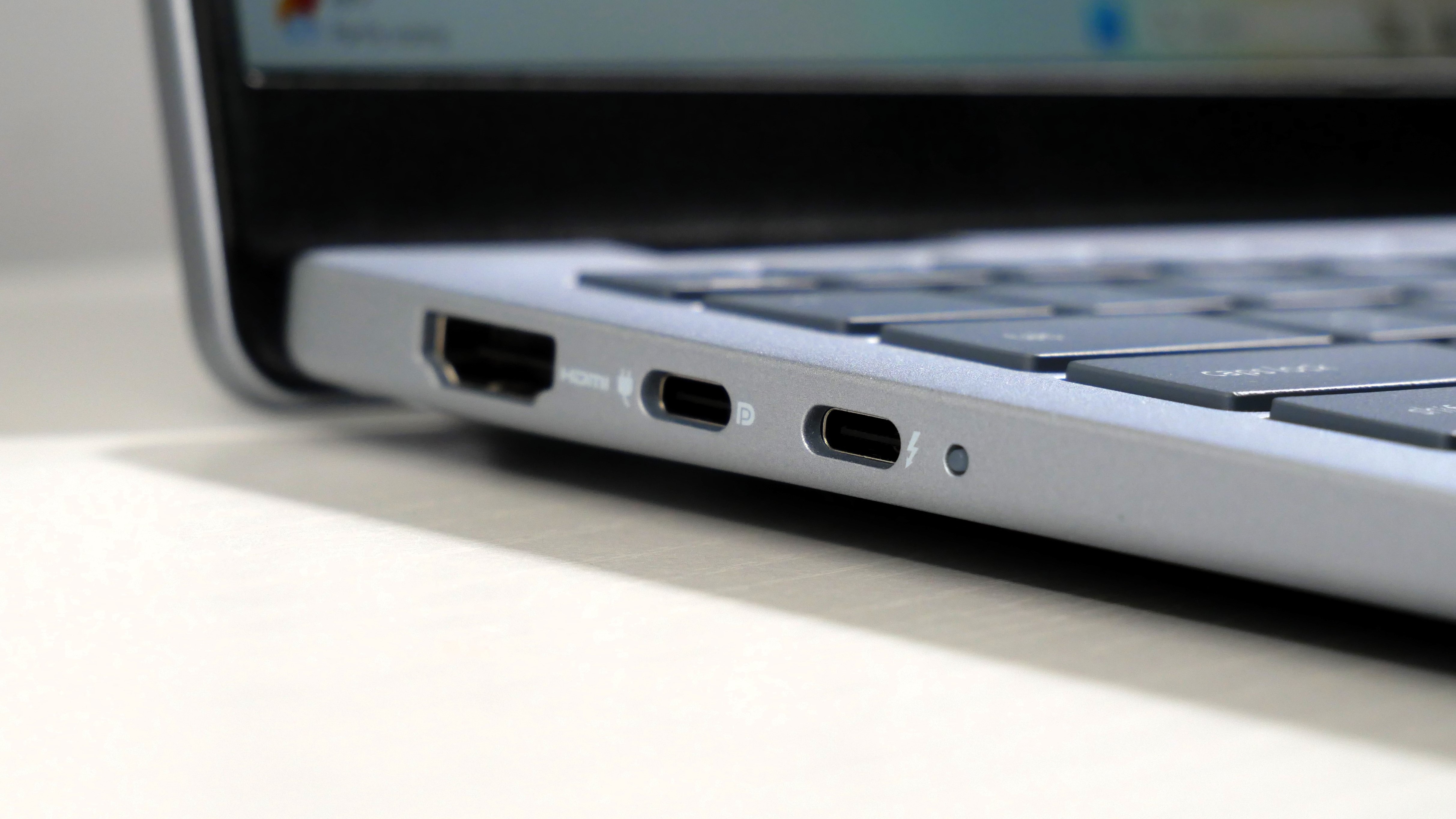 Dell 14 Plus open on a white desk, highlighting the ports on the left.