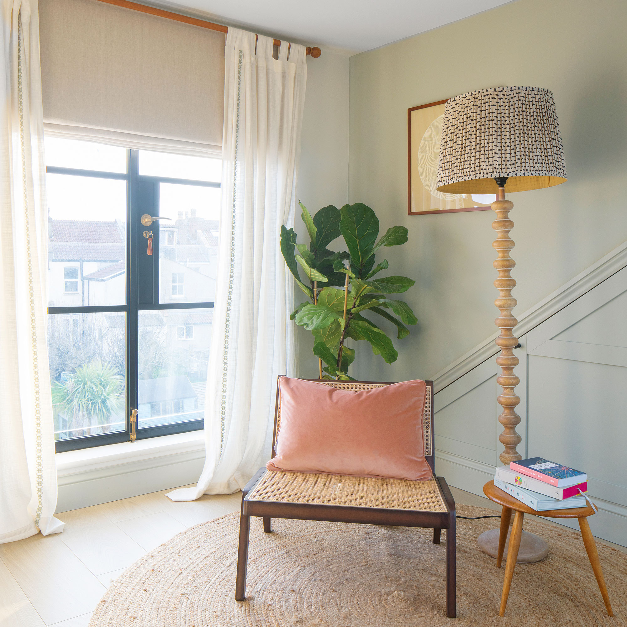 Rattan chair with side table and floor lamp on a roung jute rug
