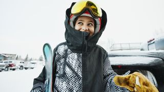 A woman smiles at a ski resort as she gets ready to ski