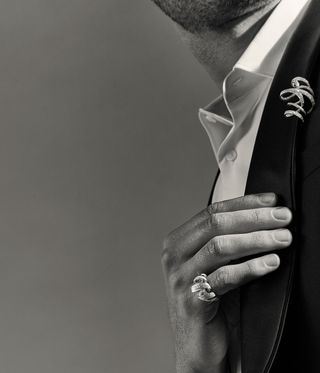 Man wearing a diamond twirl ring and diamond twirl brooch