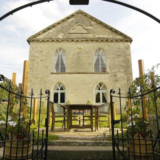 church house with gothic arched windows and stone walls