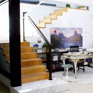 wooden stairs and painting on white wall