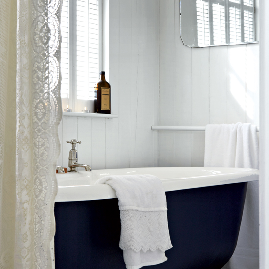 bathroom with white walls and bathtub
