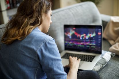 A woman looking at stock chart on a laptop.