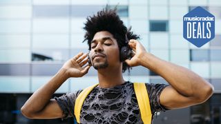 Man wearing headphones with his hands up by his ears