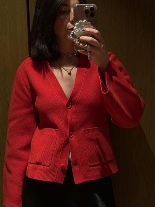 Francesca wears a red cardigan by Arket