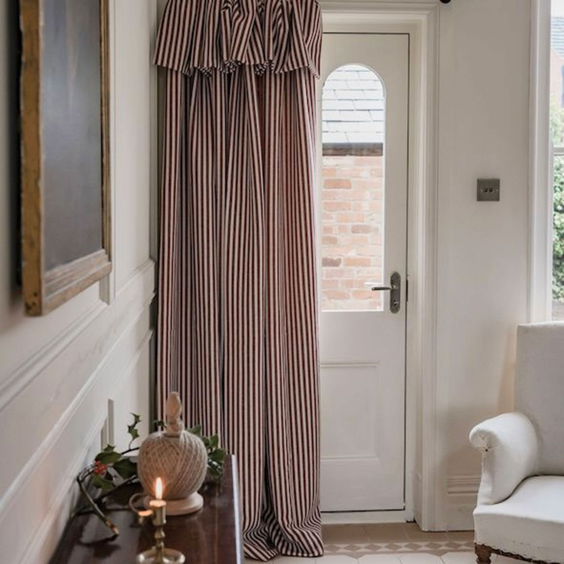 Red and white striped door curtain with ruffle in front of white door