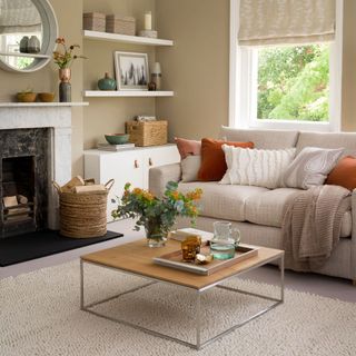 neutral living room with cream carpet beige sofa and open fireplace