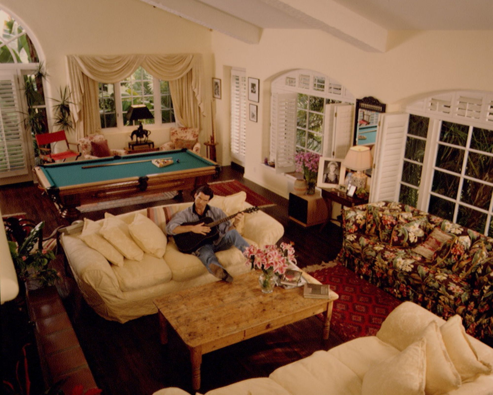 pierce brosnan in his red and yellow living room