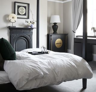 Monochrome bedroom with four poster bed and eastern influences