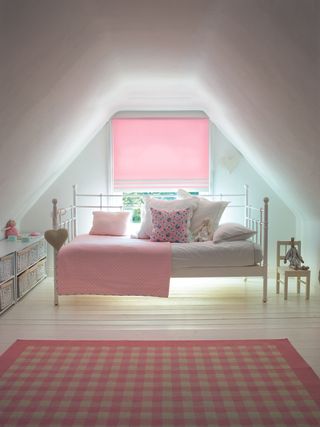 white bedroom with pink blind, check rug, day bed, pink blanket, bedroom storage