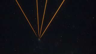 A series of golden lines converging to one point in a starry night in the center of the image