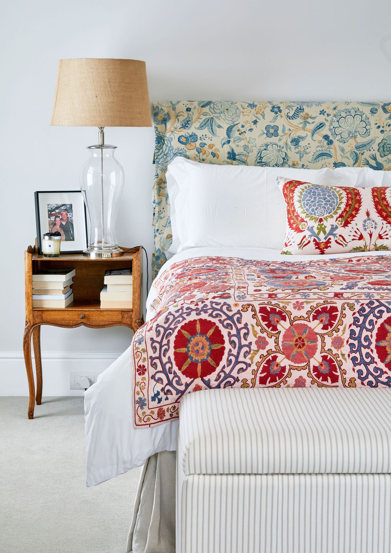 Blue, yellow and cream bed headboard, pink , red and purple blanket