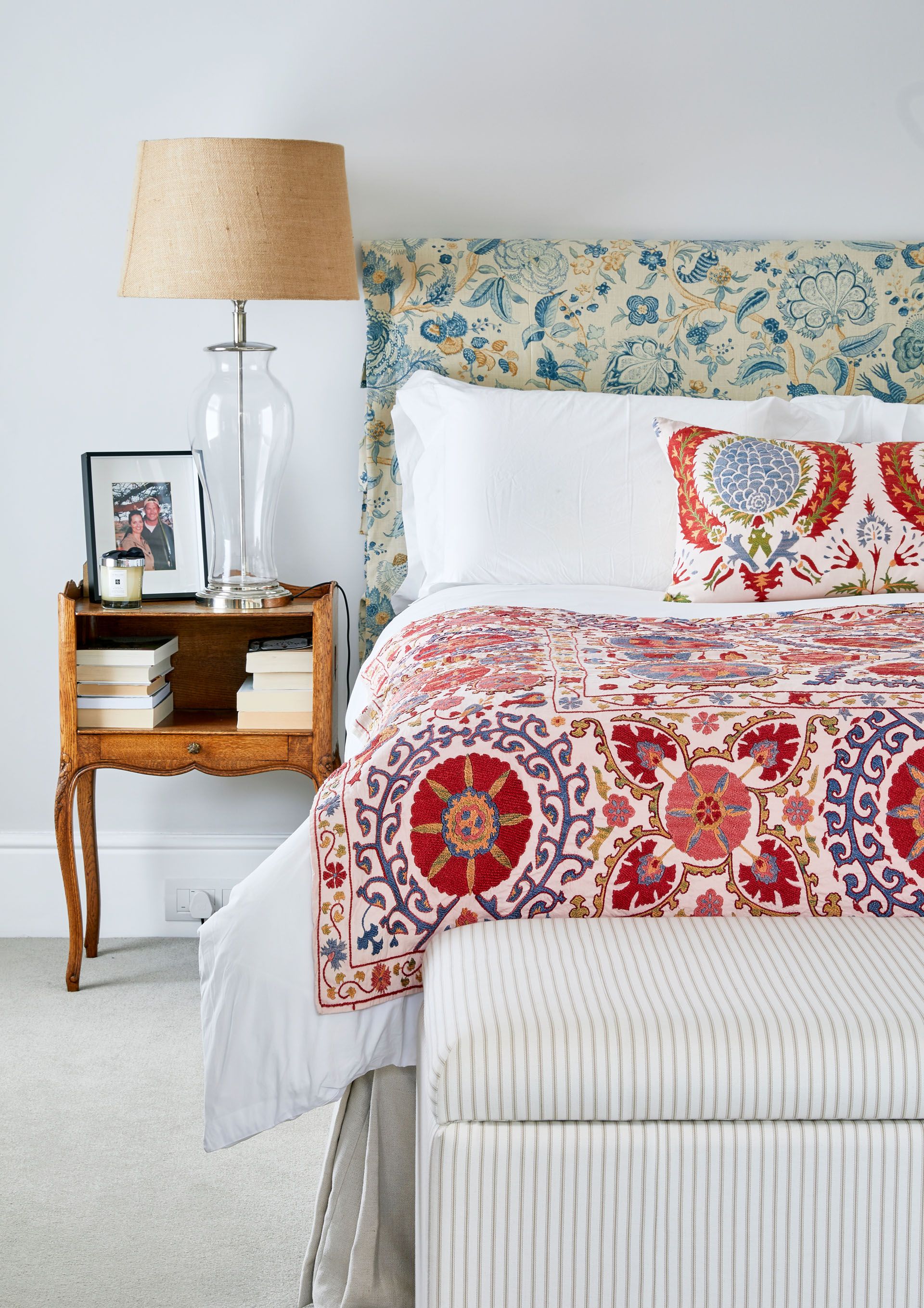 Blue, yellow and cream bed headboard, pink , red and purple blanket