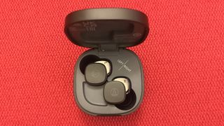 Audio-Technica ATH-SQ1TW earbuds and case on red backgound