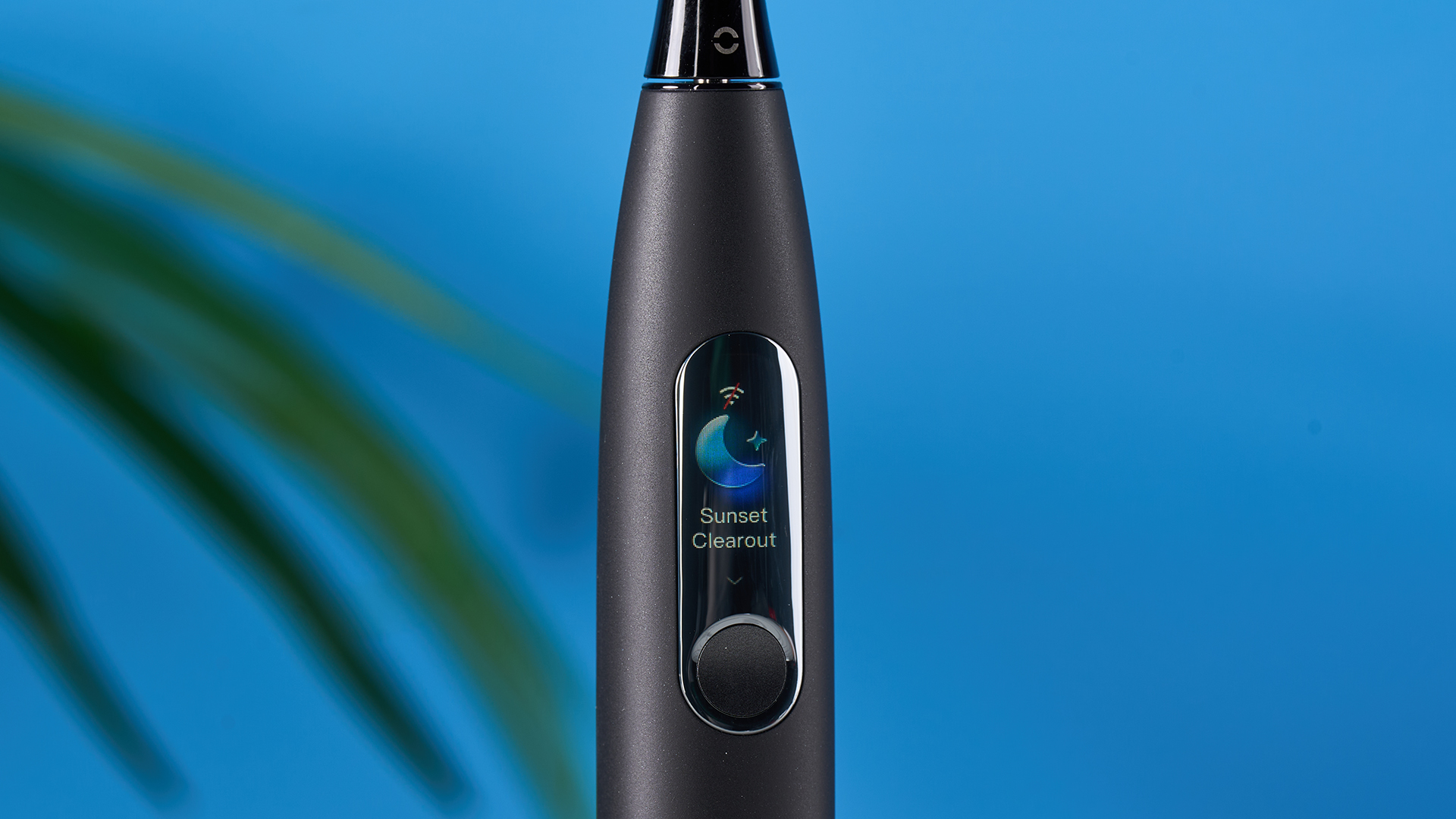 a black electric toothbrush with a small touchscreen and a blue toothbrush head and a square charging stand