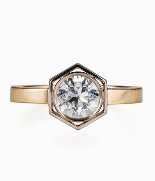 Liv Luttrell's Ring with a circular shaped diamond stone, with a gold trim and a hexagonal holder.