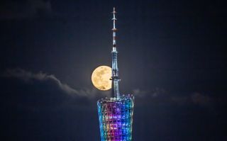 The Flower Moon rises over the Canton tower in Guangzhou, Guangdong Province of China on May 7, 2020.