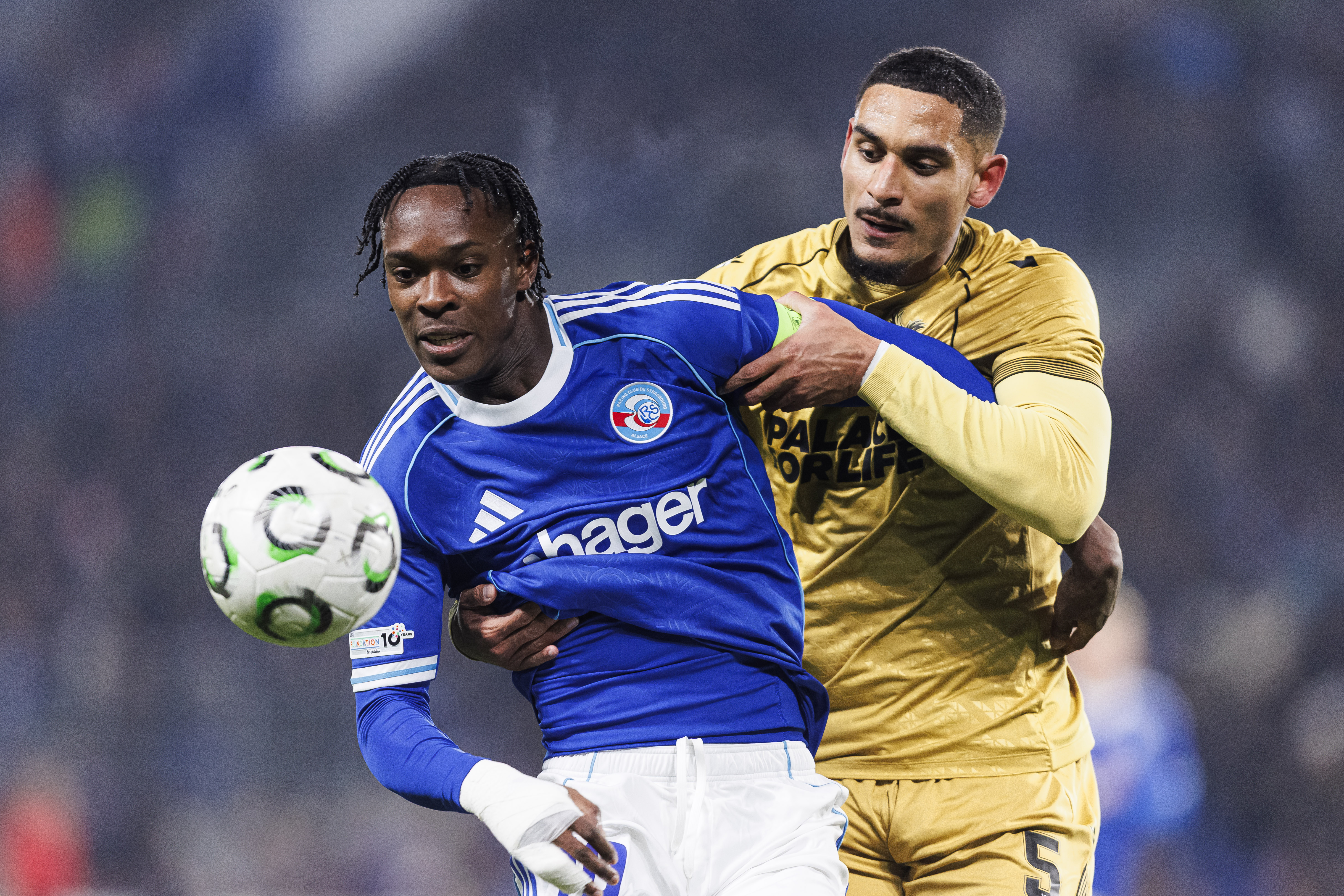 STRASBOURG, FRANCE - NOVEMBER 27: Maxence Lacroix of Crystal Palace (R) puts a tackle on Emmanuel Emegha of Strasbourg (L) during the UEFA Conference League 2025/26 League Phase MD4 match between Racing Club de Strasbourg Alsace and Crystal Palace FC at Stade de la Meinau on November 27, 2025 in Strasbourg, France. (Photo by Sathire Kelpa/Eurasia Sport Images/Getty Images)