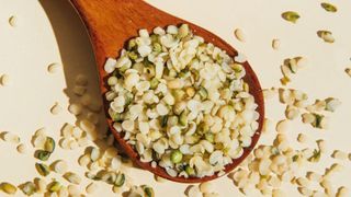 Wooden spoon with pile of hemp seeds