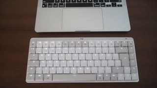 A white Logitech MX Keys Mini for Mac keyboard sitting on a desk