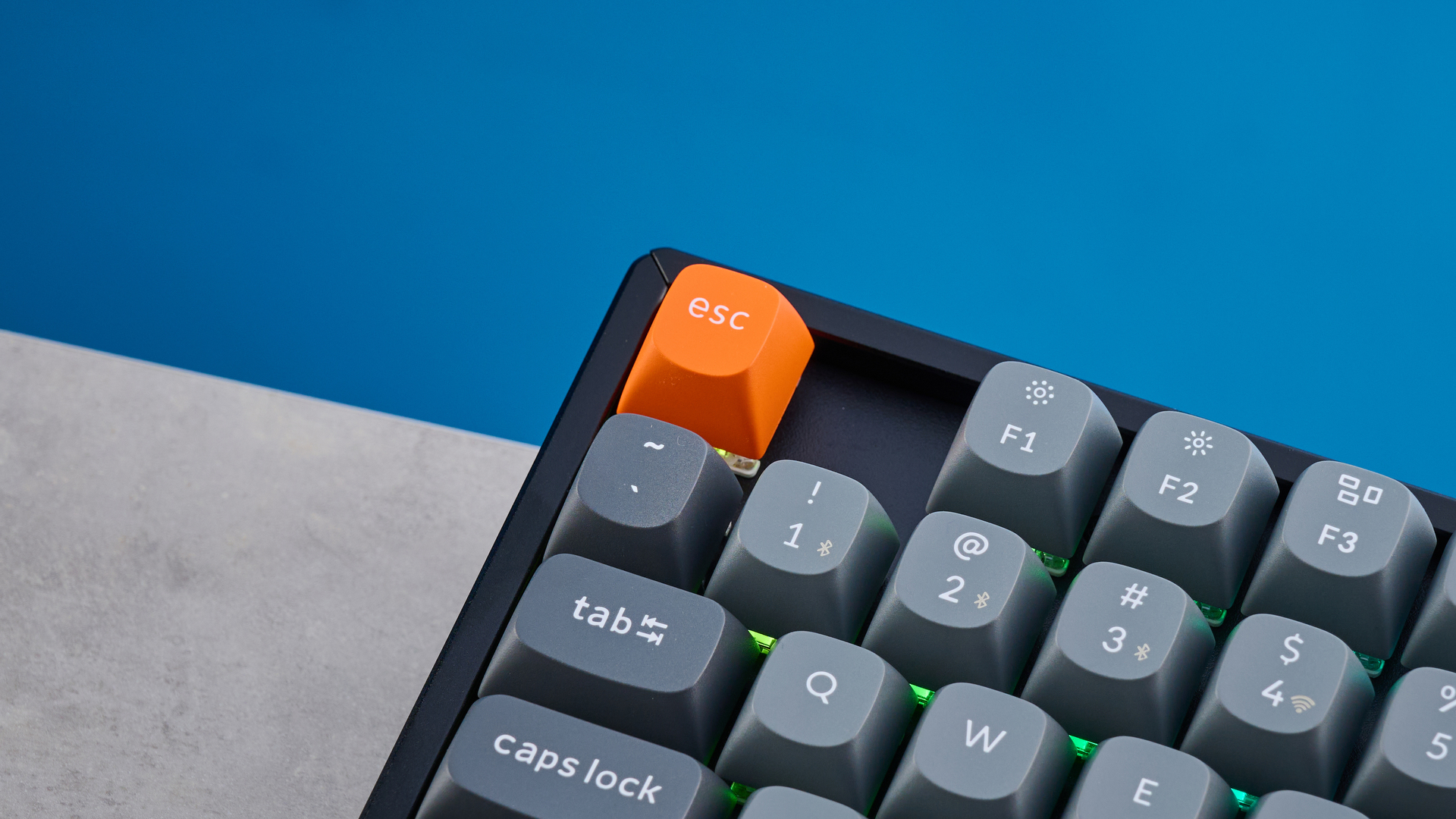 Keychron K8 Max mechanical keyboard in gray photographed on a blue background