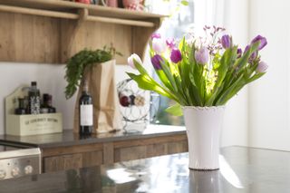 Tulips in a vase, kept atop the kitchen counter