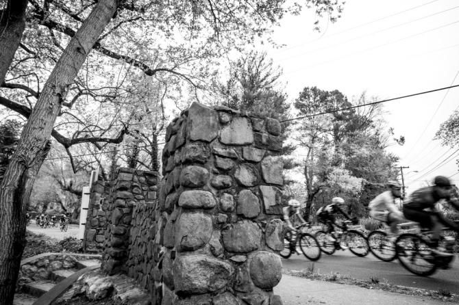Riders pass by a park along the course.