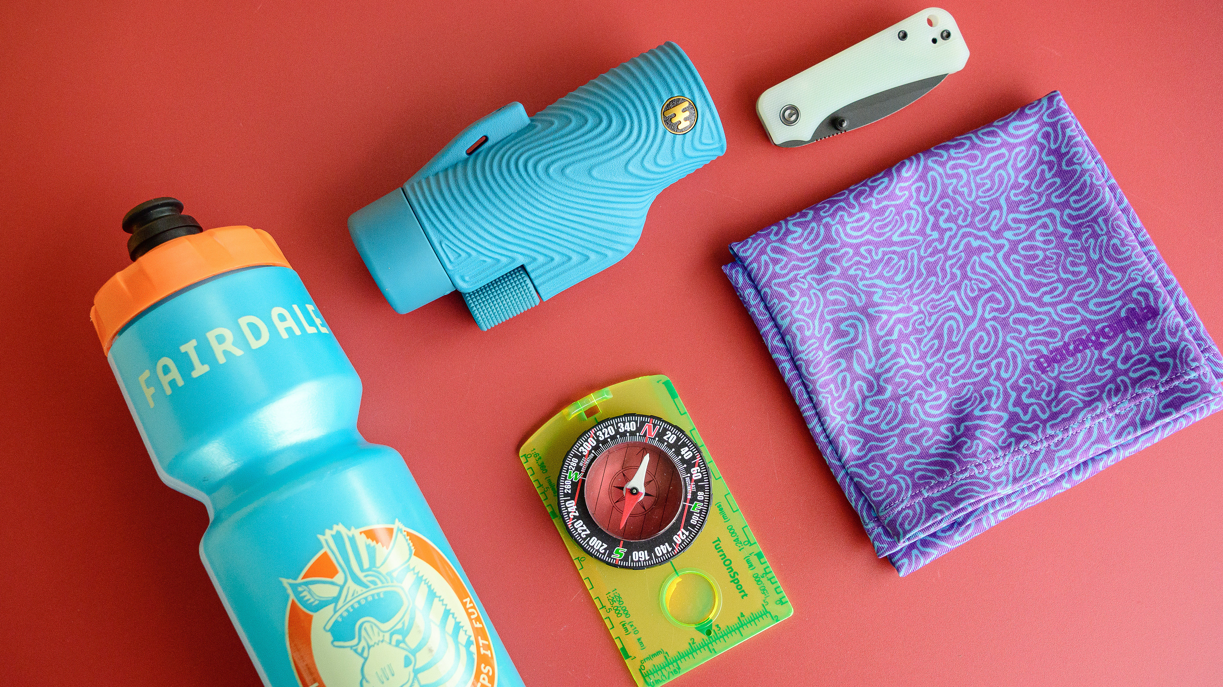 5 affordable items to bring on your next hike, including a bike water bottle, compass, neck gaiter, rugged telescope and everyday carry knife.